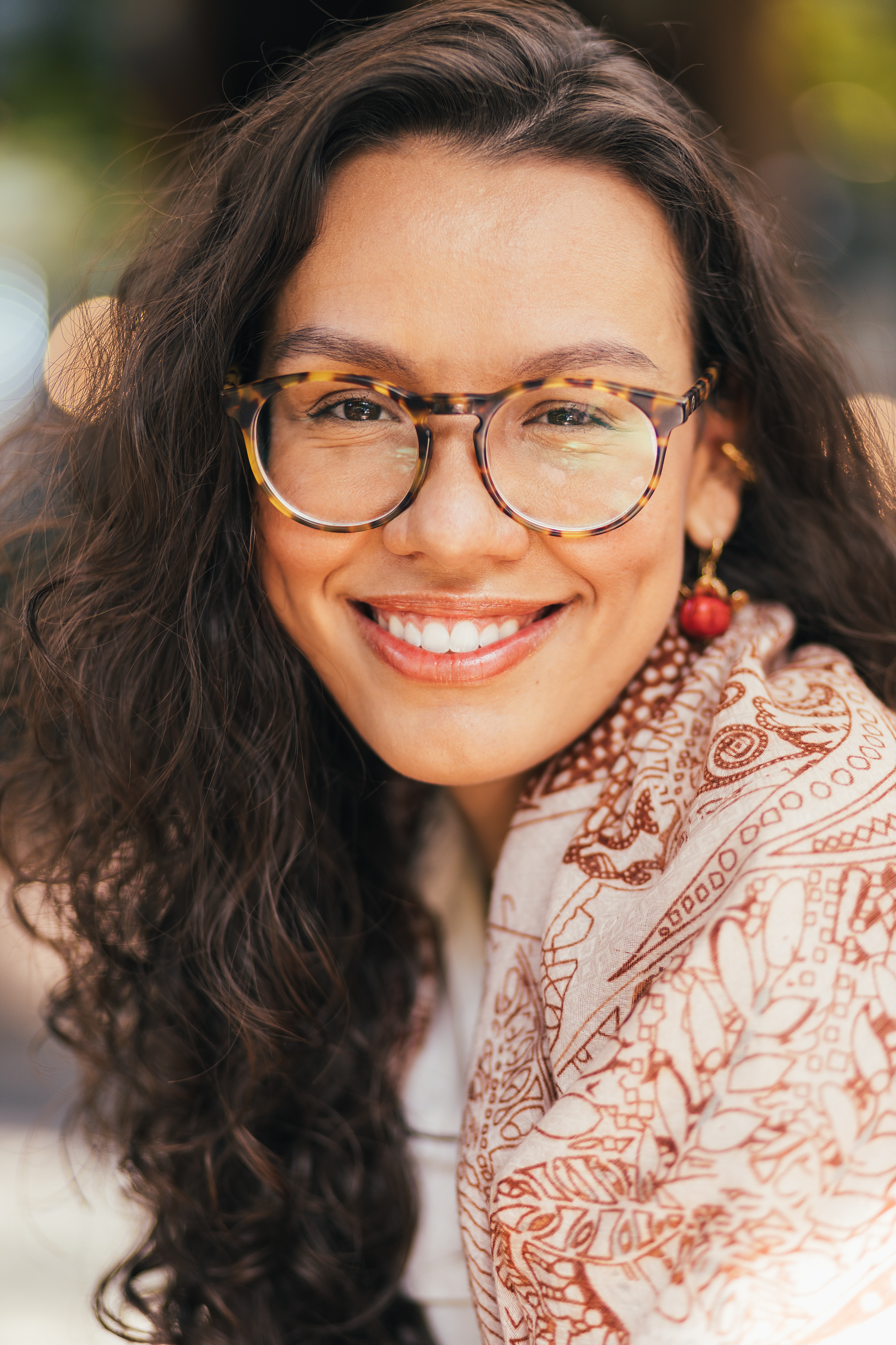 Mujer sonriendo con lentes redondos, adaptándose con comodidad a su nueva graduación